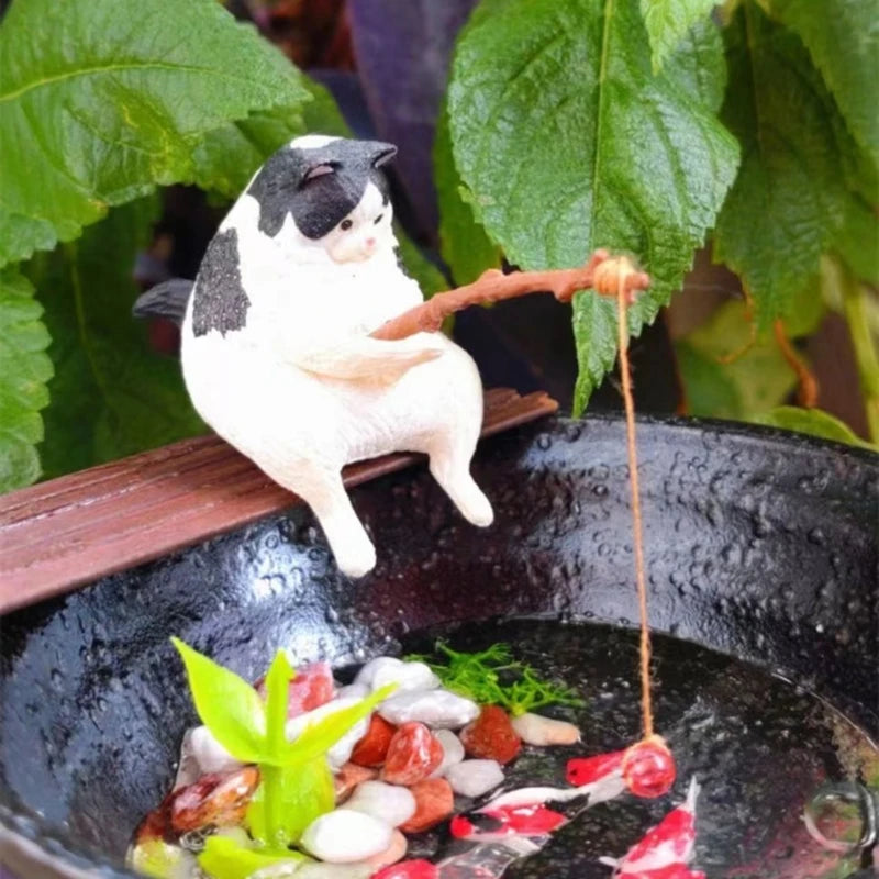 Cat figurine on a wooden perch over a bowl with food and plants