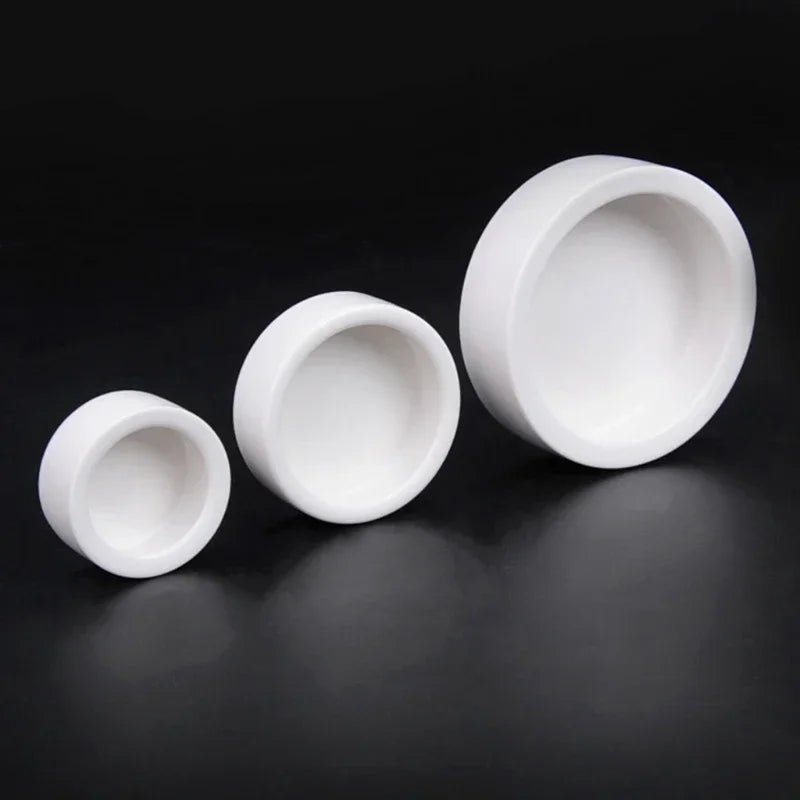 Three white ceramic bowls of different sizes on a black background