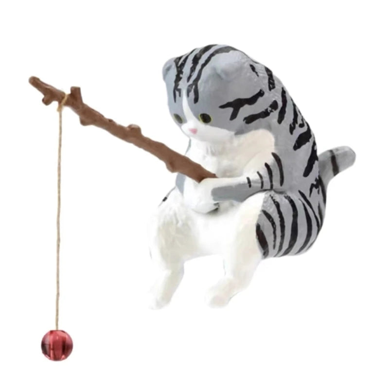 Plush toy of a cat climbing a branch with a red ball on a white background