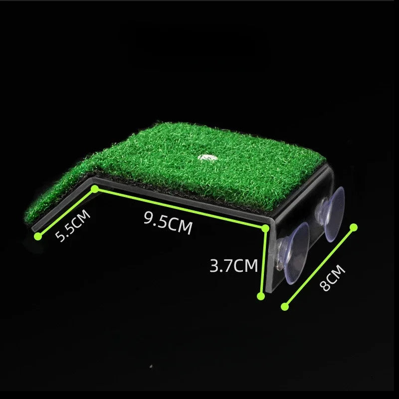 A rectangular black device with a green artificial grass top and two clear suction cups on one end, shown on a black background with green dimension lines and labels reading 5.5CM, 9.
