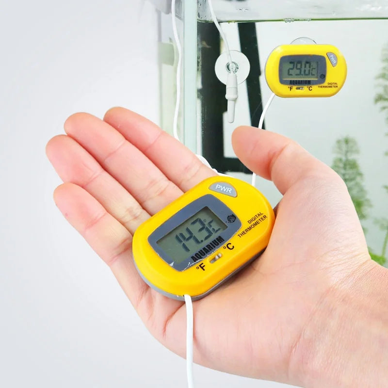 Yellow digital thermometer held in a hand with a blurred outdoor background